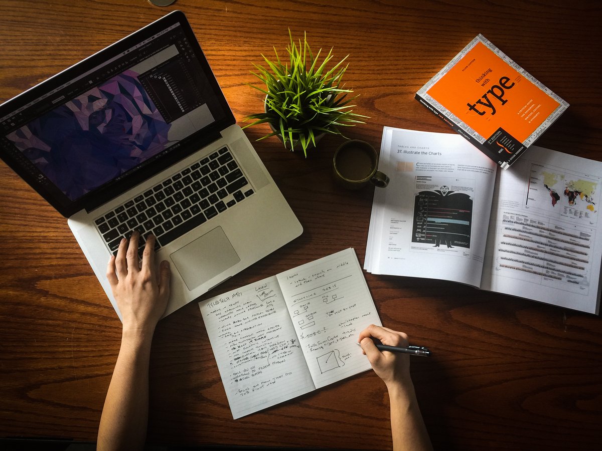 Image of a laptop, a plant and notes on a desk - Guide to turning your blog into a profitable career - Image