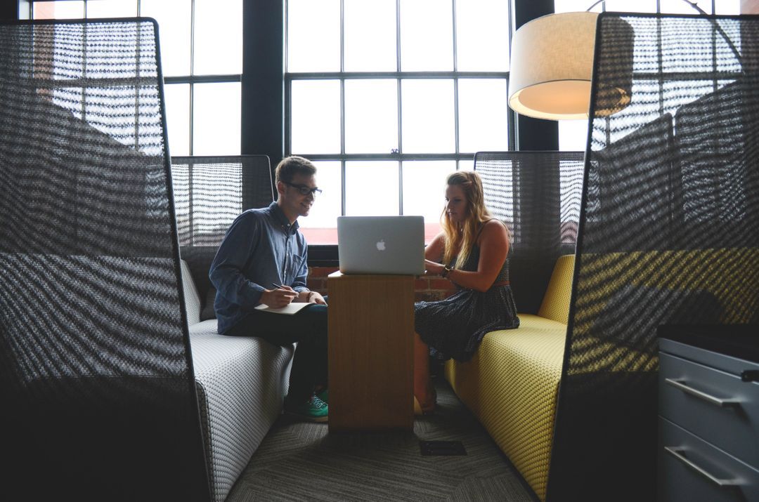 Two people working together on one laptop - How to adapt social media strategy to keep your audience engaged - Image