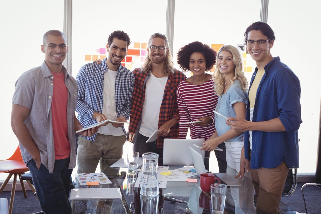 Image of six people standing at a table and laughing at the camera - 25 useful social media marketing ideas for boosting engagement - Image