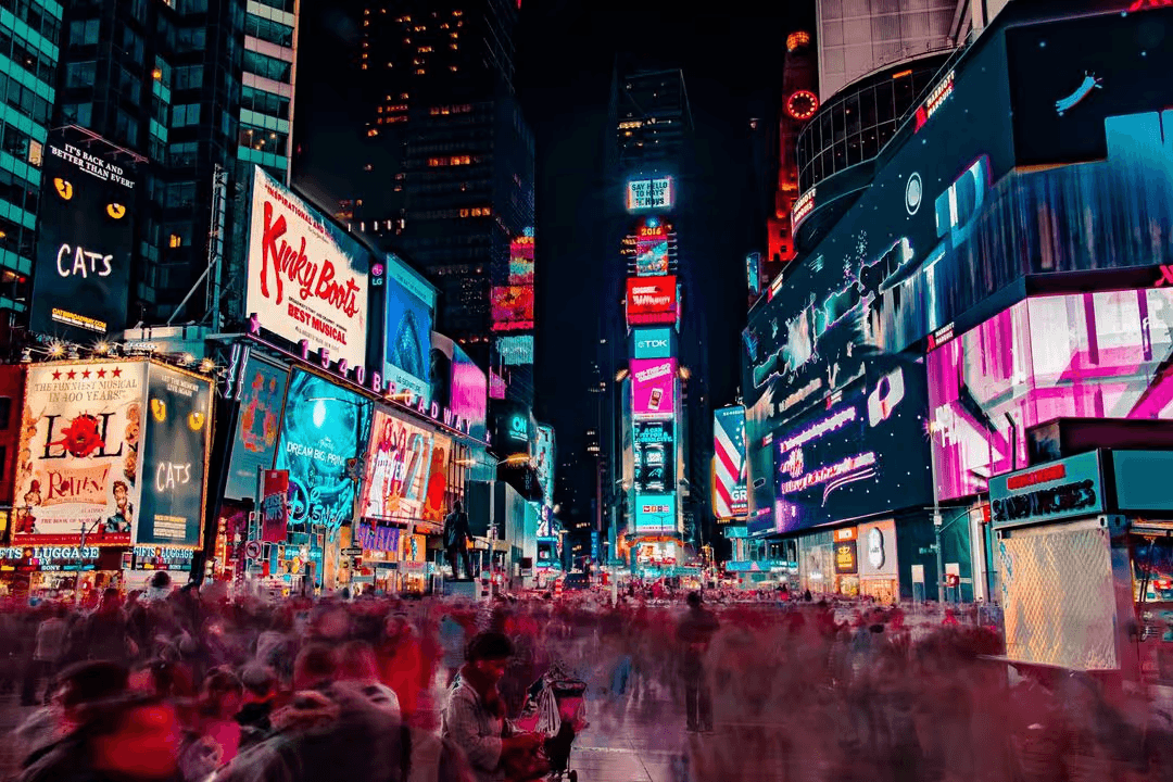 Slow motion image of people walking through New York City with bright billboards in the background - Expert online marketing tips to improve your digital strategy and make more money - Image