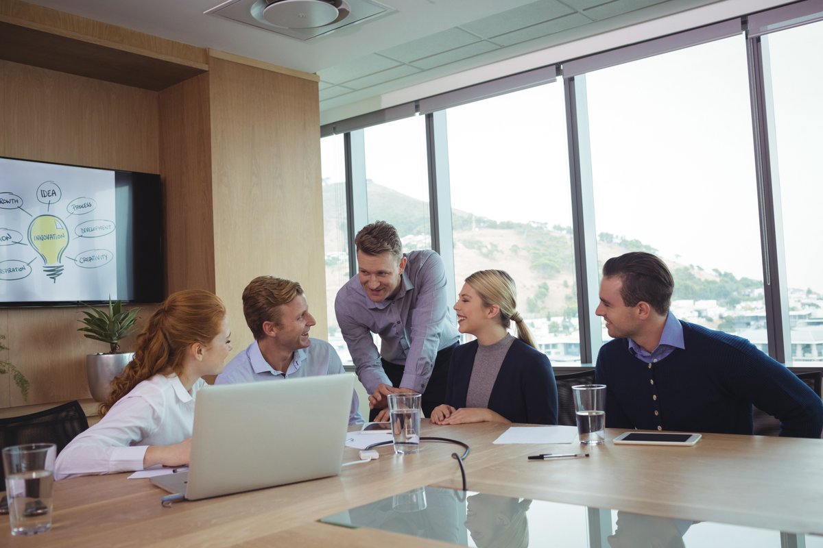 Image of a group of five people discussing something in a meeting - 35 inspiring marketing quotes to motivate your team and improve conversions - Image