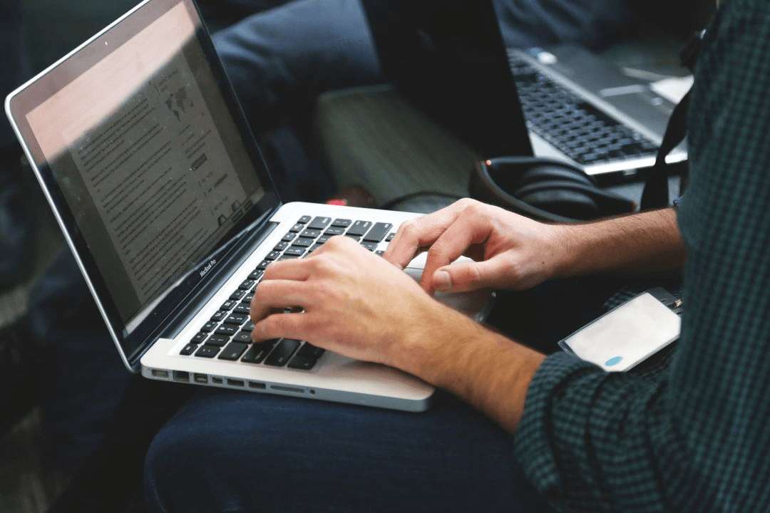 Image of a man using his laptop on his lap - Retail marketing strategy tips and tricks to drive sales and save money - Image