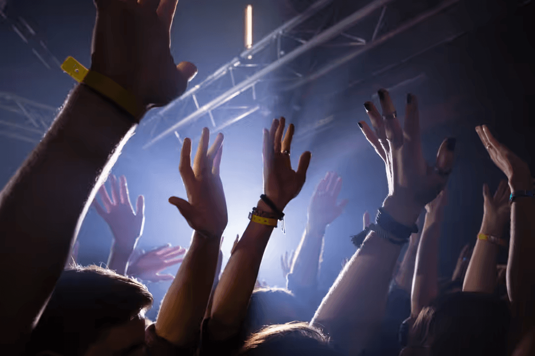 Hands up in the air at a concert - Retail marketing strategy tips and tricks to drive sales and save money - Image
