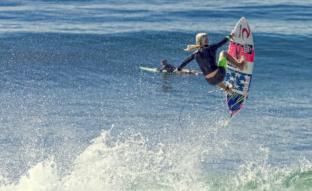 Image of two surfers riding a big wave - Meaning and use of hero image in web design - Image