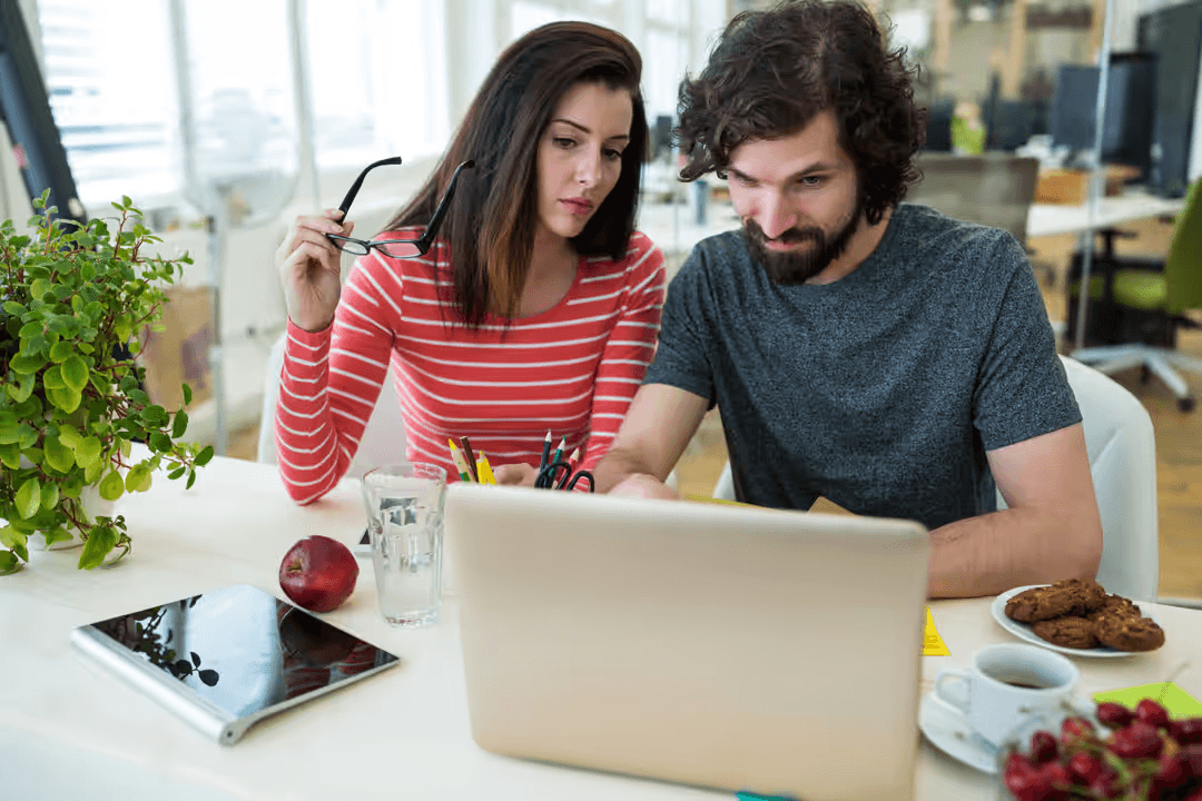 Image of a man and a woman using a laptop together - Customer support is critical to growing your business - Image