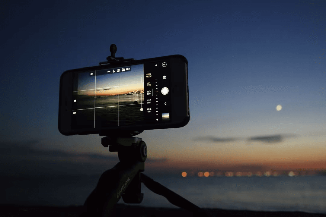 Smartphone on a tripod taking pictures of a sunset - Risks of using copyrighted photos - Image