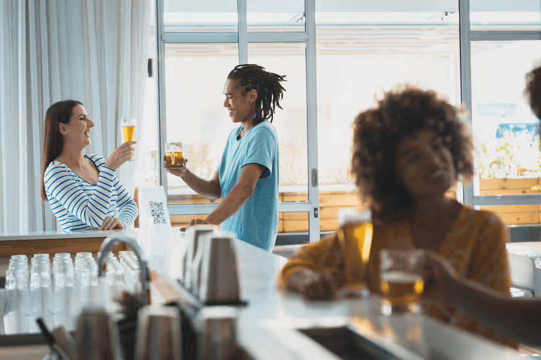 Group of people celebrating with drinks at a local bar - Retail marketing strategy tips and tricks to drive sales and save money - Image