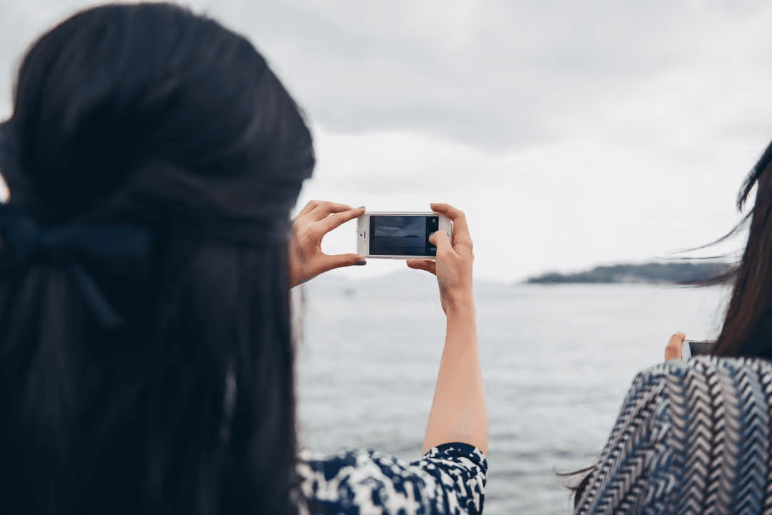 Image of two woman taking a picture with a smartphone - Photo ownership and restrictions - Image