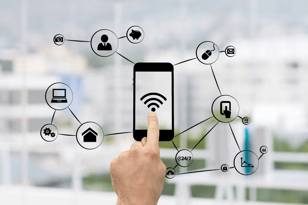Image of a hand pointing to a graphic of a phone surrounded by technology - How to make a beautiful digital vision board with free online tools in 5 steps - Image