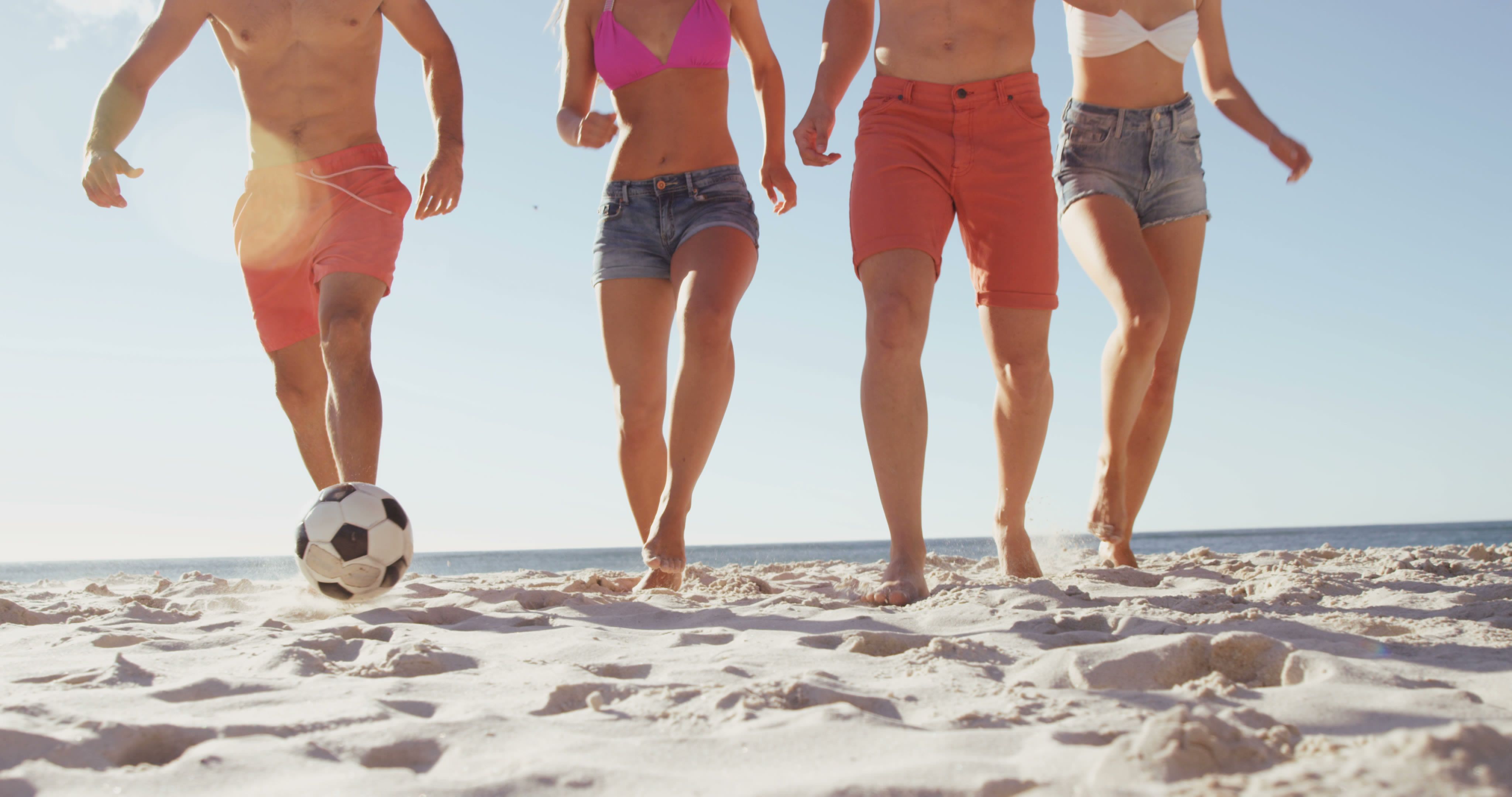 Friends Playing Beach Soccer In Sun Kissed Summer Scene