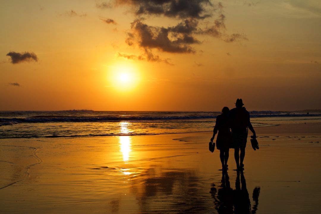 Couple walking along the beach at dusk