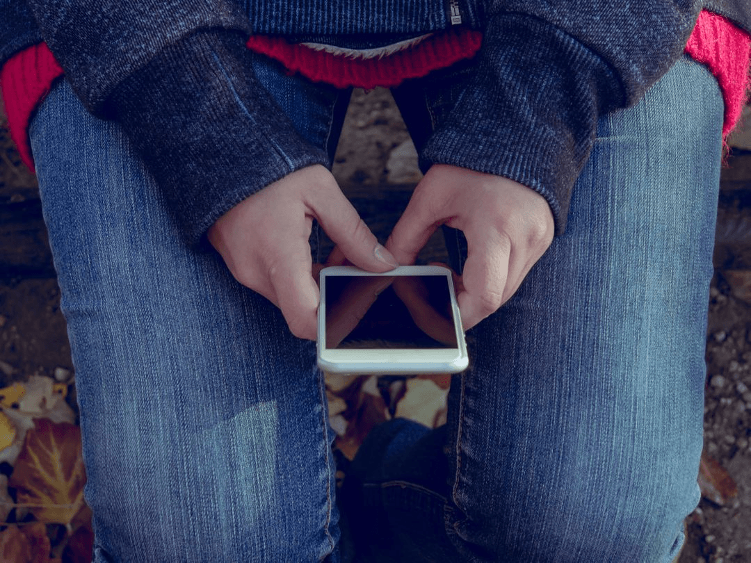 Image of a woman with a smartphone in her hands - Six types of graphics you need to know for business marketing - Image