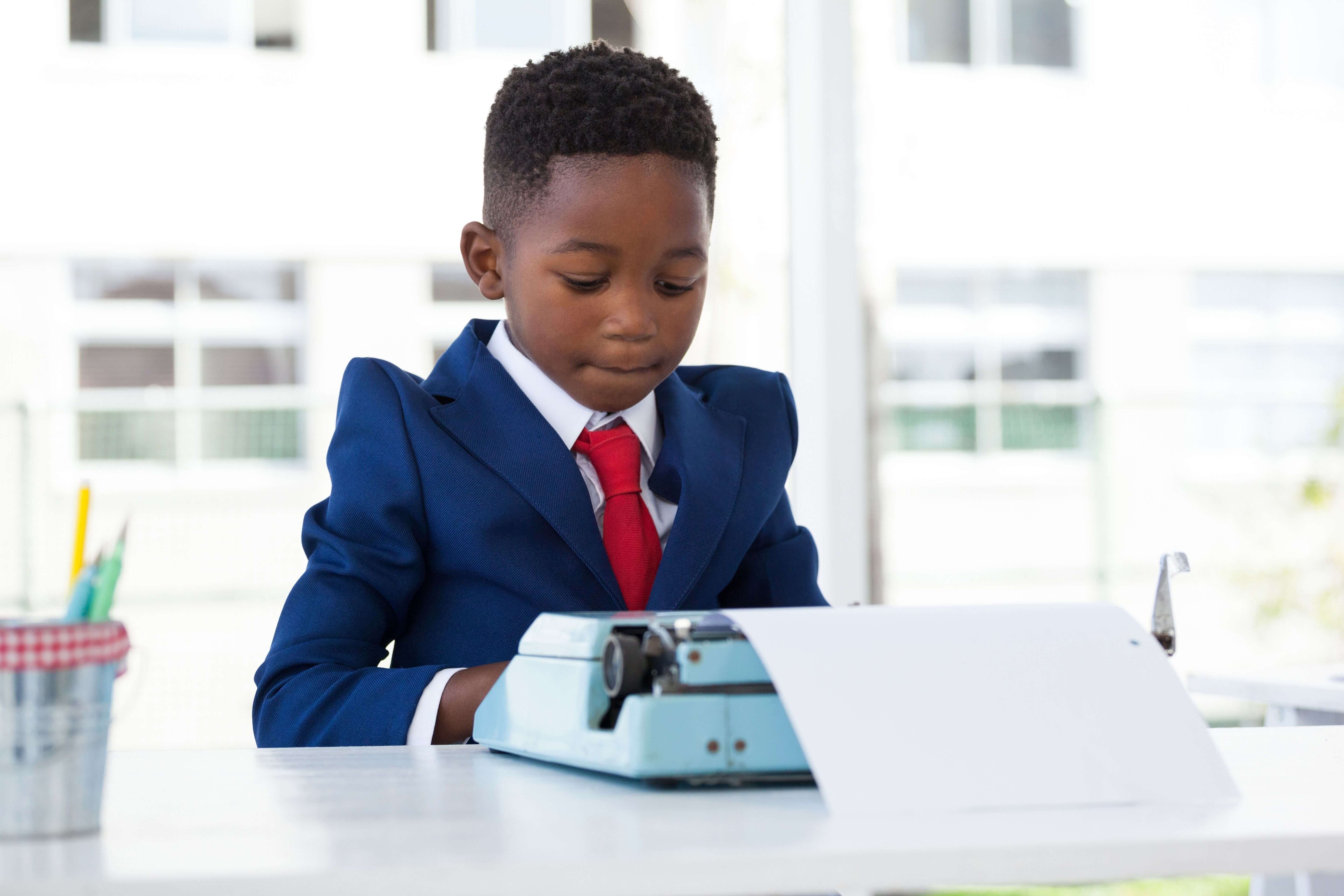 Child wearing a suit using a typewriter - Tool recommendations for the aspiring writer - Image