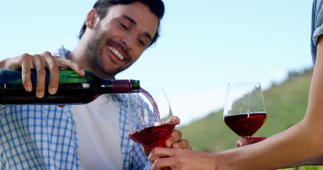 Smiling Man Pouring Red Wine Outdoors at Vineyard - Free Images, Stock Photos and Pictures on Pikwizard.com