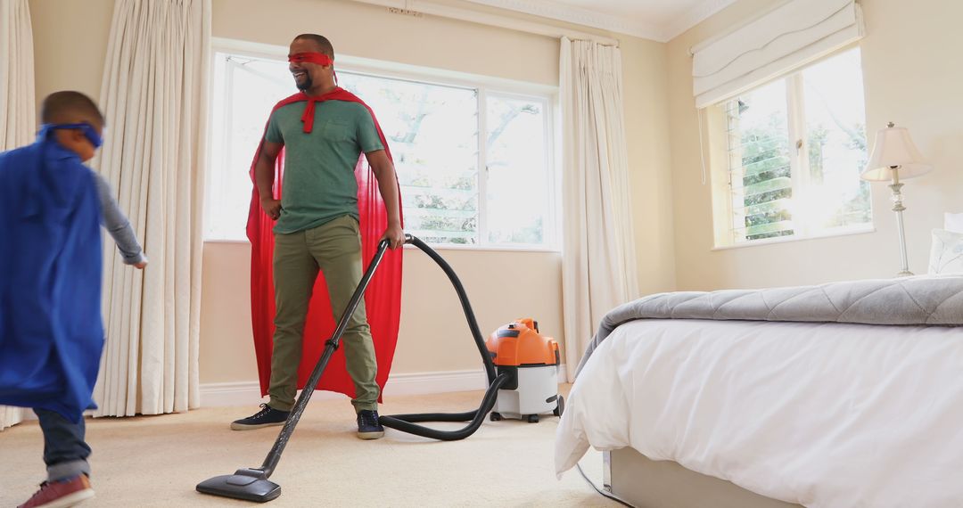 Father and Son Pretending to Be Superheroes While Vacuuming Home - Free Images, Stock Photos and Pictures on Pikwizard.com