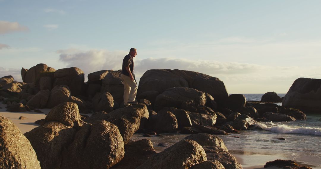 Man Exploring Rocky Beach at Sunset - Free Images, Stock Photos and Pictures on Pikwizard.com