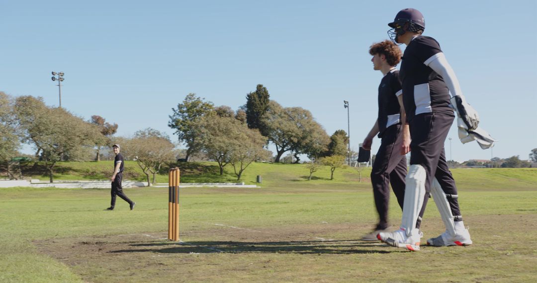 Cricketers Engaged in Competitive Match on Grass Field