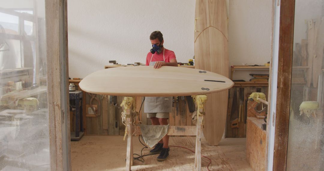 Caucasian Surfboard Maker Buffing Wooden Board in Workshop - Free Images, Stock Photos and Pictures on Pikwizard.com