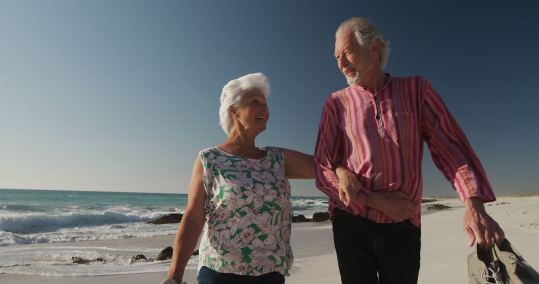 Senior Couple Enjoying Beach Walk on Sunny Day - Free Images, Stock Photos and Pictures on Pikwizard.com