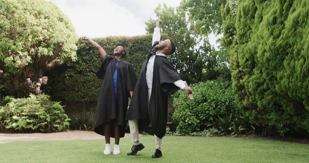 Joyful Graduates Wearing Caps and Gowns Celebrating in a Garden