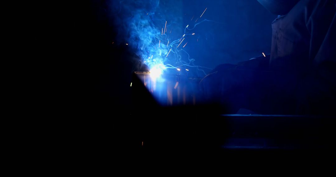 A welder works in a dark setting, creating a bright arc of light - Free Images, Stock Photos and Pictures on Pikwizard.com