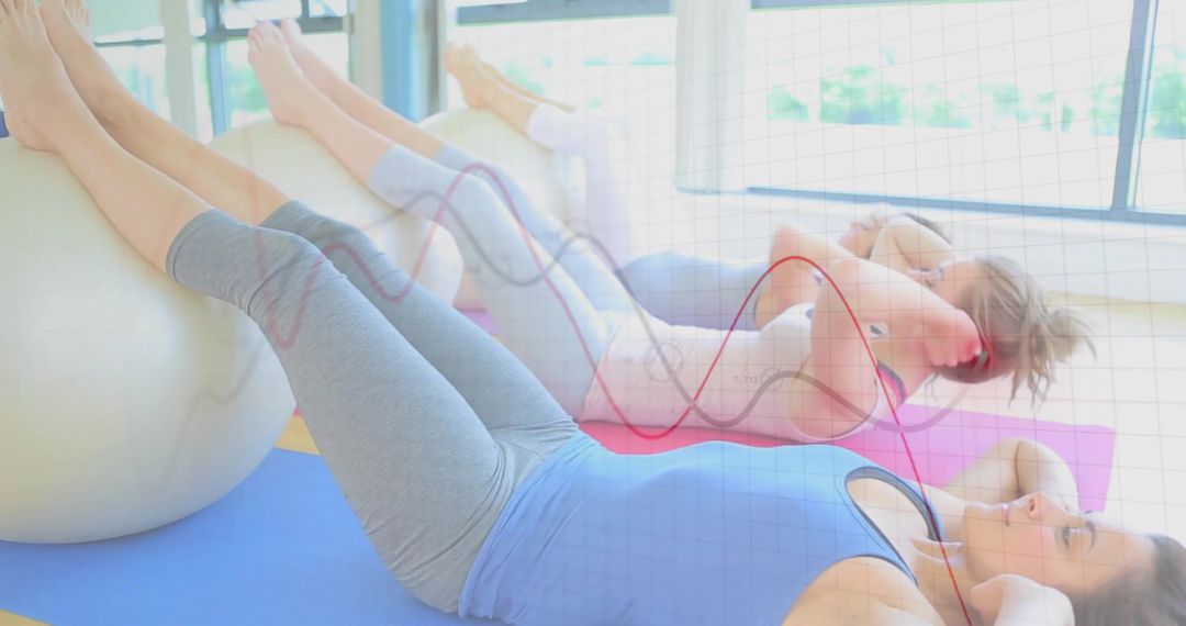 Women Performing Stability Ball Crunches in Bright Studio Fitness Class Strengthening Core