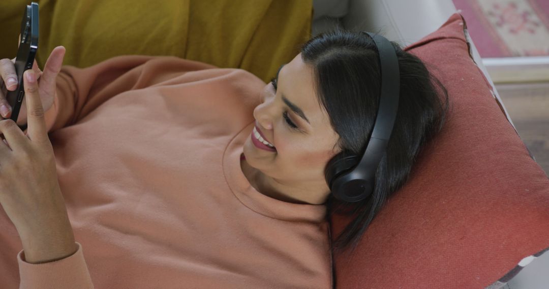 Woman Relaxing with Headphones and Smartphone on Sofa - Free Images, Stock Photos and Pictures on Pikwizard.com