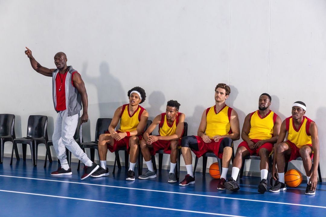 Basketball Coach Motivating Players on Bench During Training Session