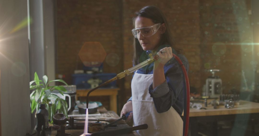Caucasian Woman Using Blowtorch in Artisan Workshop