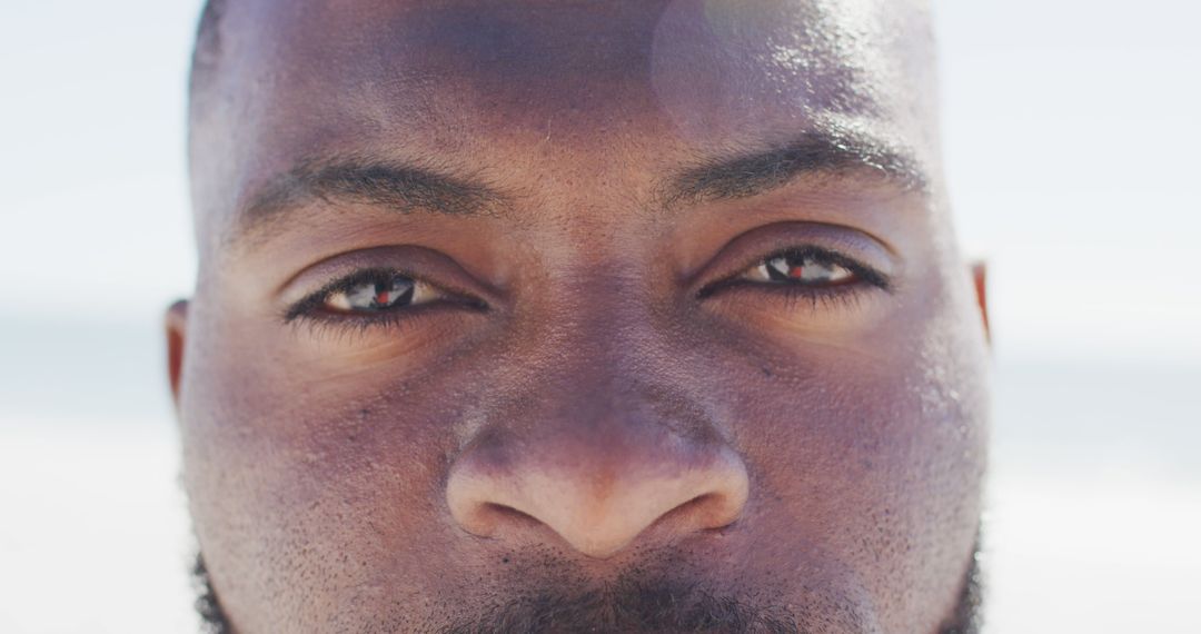 Close-up Portrait of Man Gazing at Camera on Sunny Beach - Free Images, Stock Photos and Pictures on Pikwizard.com