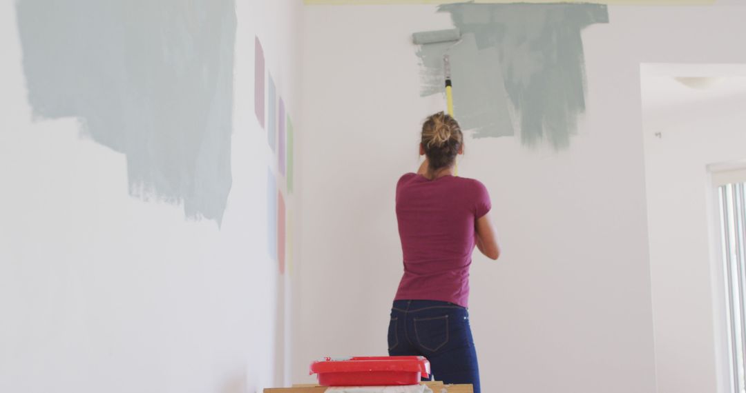 Caucasian woman painting walls with gray paint - Free Images, Stock Photos and Pictures on Pikwizard.com