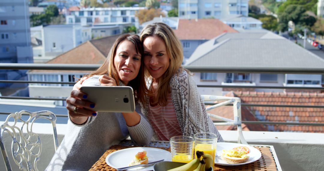 Two Women Taking Selfie on Terrace Over Breakfast - Free Images, Stock Photos and Pictures on Pikwizard.com