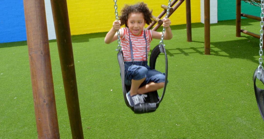 Cheerful Child Swinging at Vibrant Playground in Slow Motion