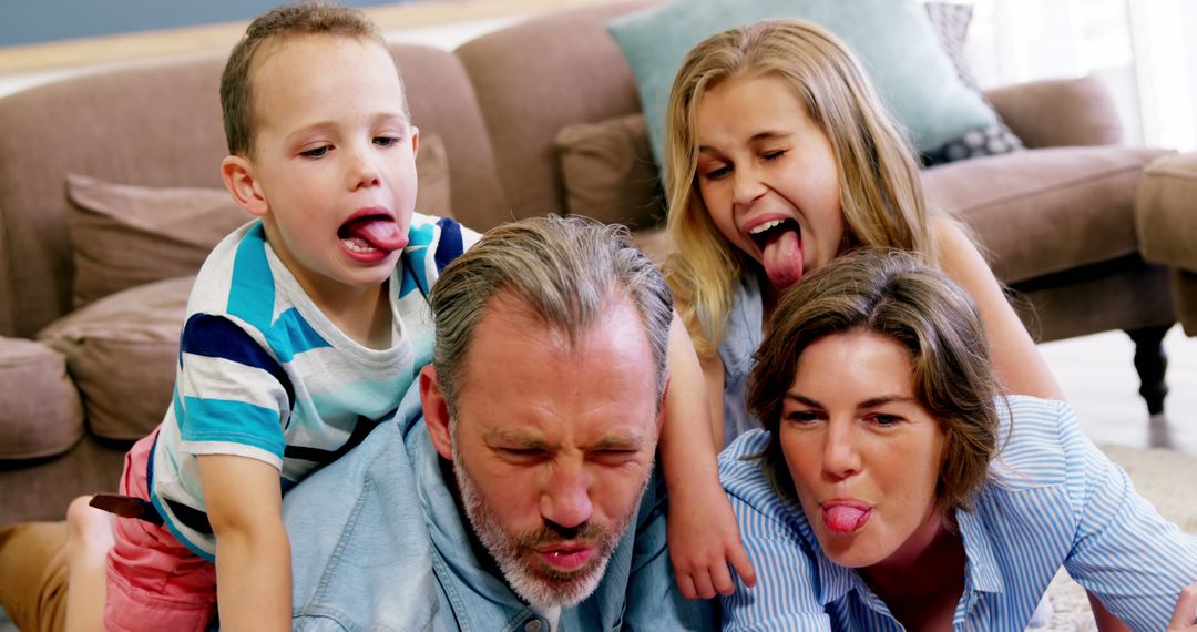 Happy Family Sticking Out Tongues Having Fun Indoors - Free Images, Stock Photos and Pictures on Pikwizard.com