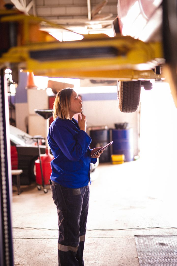 Female Mechanic Inspecting Car in Auto Repair Shop - Free Images, Stock Photos and Pictures on Pikwizard.com