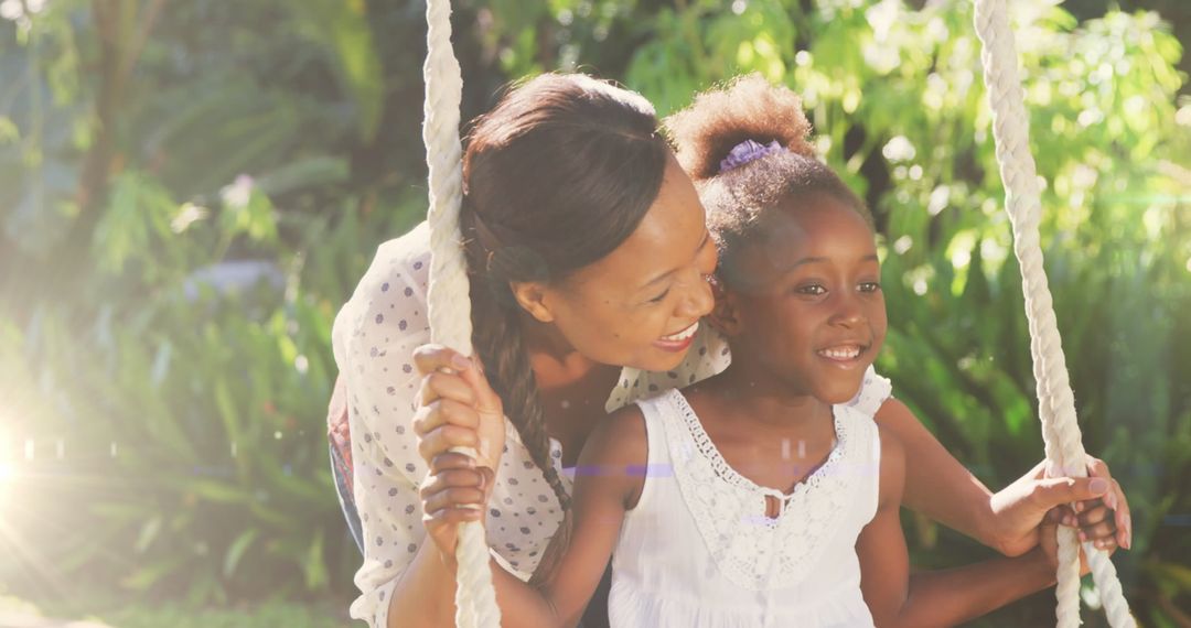 Mother and Daughter Enjoying Sunshine Swing in Garden
