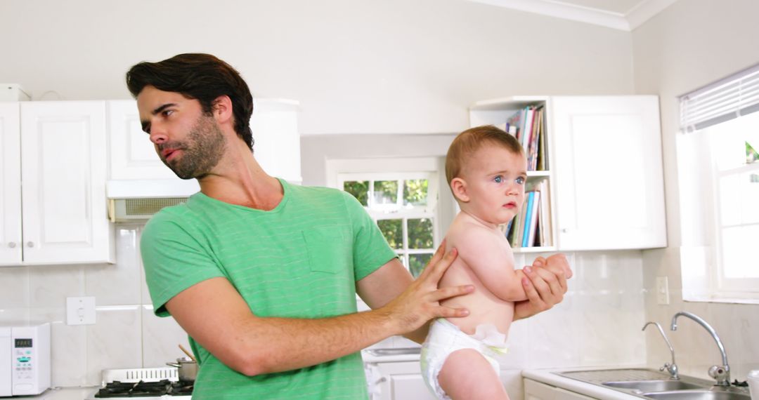 Father Holding Baby in Kitchen Interior with Light - Free Images, Stock Photos and Pictures on Pikwizard.com