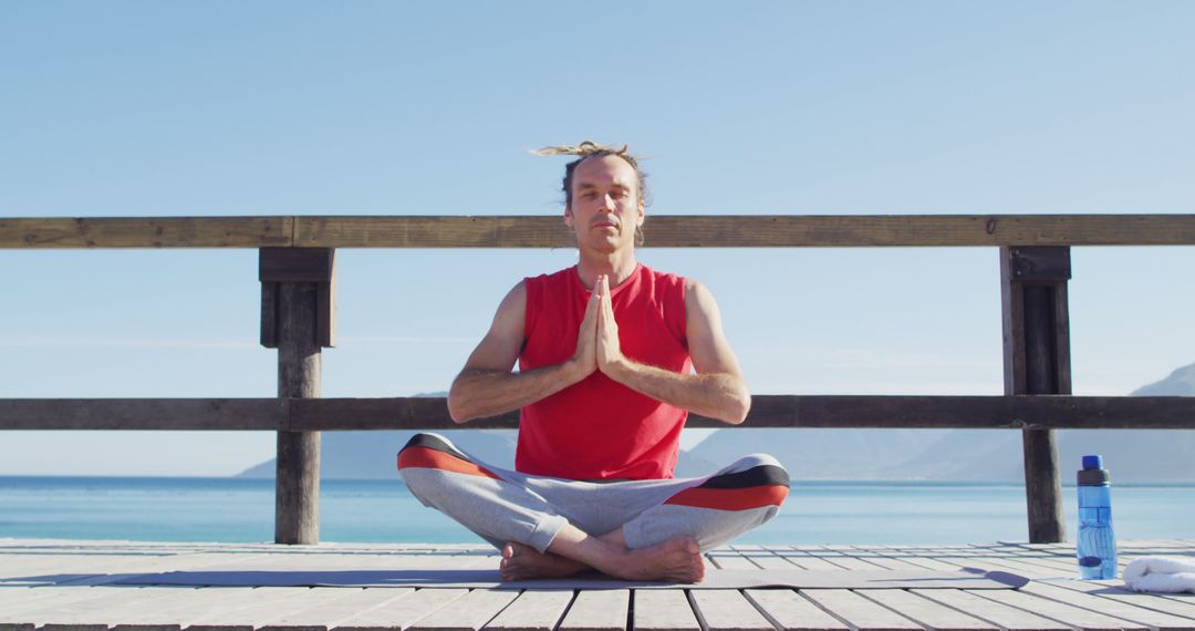 Man with Dreadlocks Meditating on Seaside Terrace - Free Images, Stock Photos and Pictures on Pikwizard.com