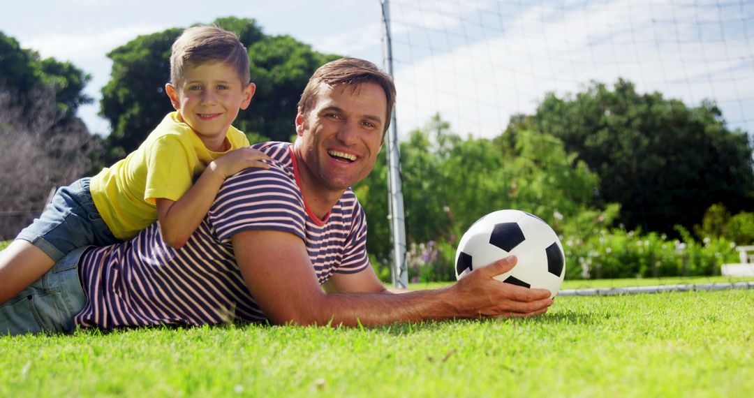 Father and Son Enjoying Outdoor Soccer Game - Free Images, Stock Photos and Pictures on Pikwizard.com