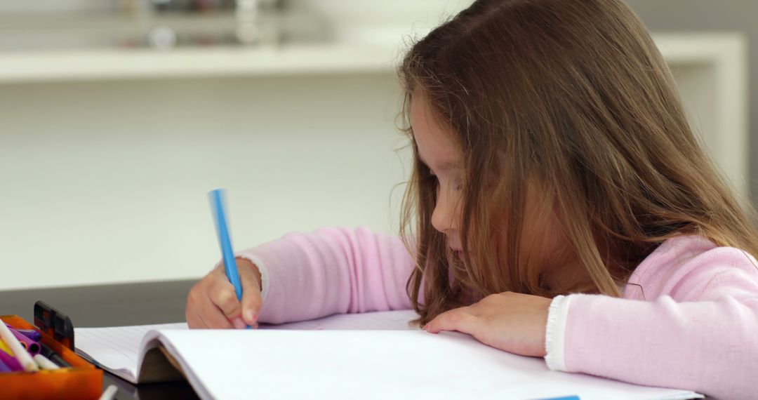 Young Girl Writing in Notebook with Blue Pen - Free Images, Stock Photos and Pictures on Pikwizard.com