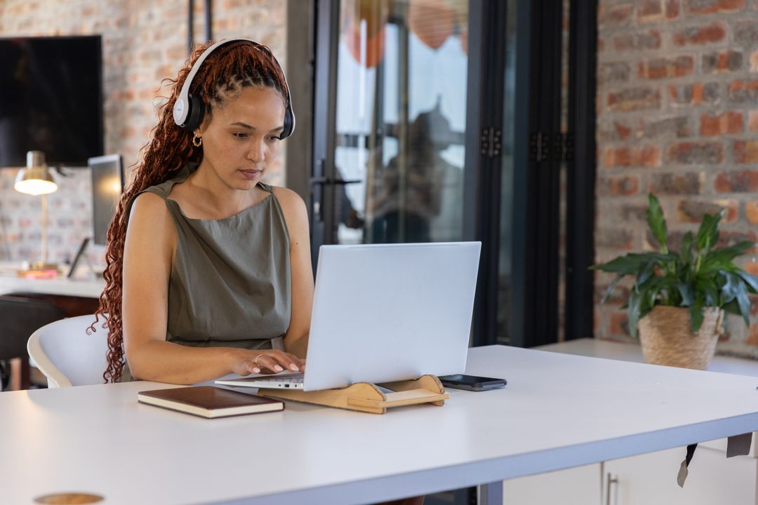 Focused Professional in Office Typing on Laptop