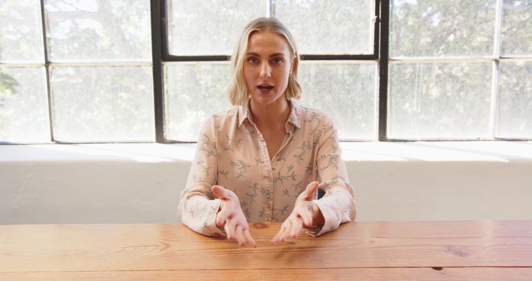 Businesswoman Presenting with Gestures at Wooden Table