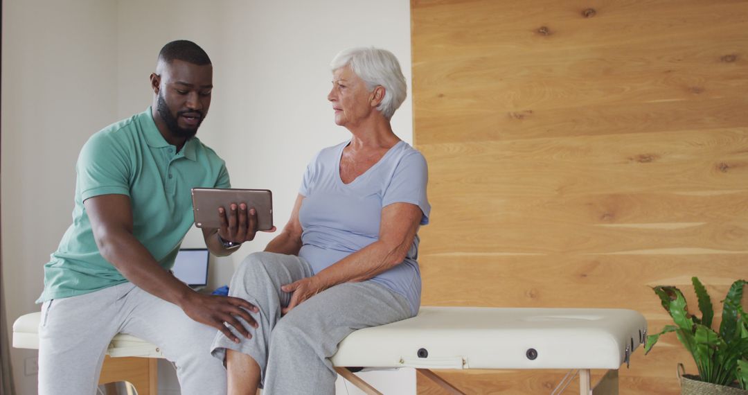 Physical Therapist Showing Elderly Patient Treatment Plan on Tablet - Free Images, Stock Photos and Pictures on Pikwizard.com