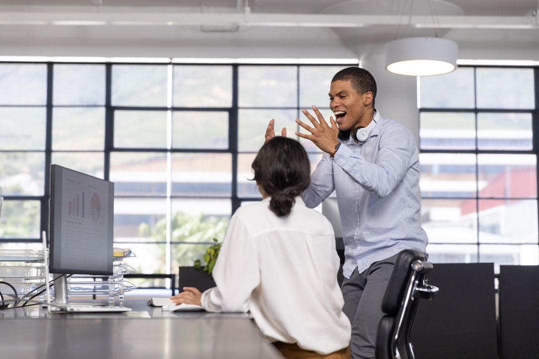 Colleagues Engaging in a Vibrant Desk Discussion at Modern Office