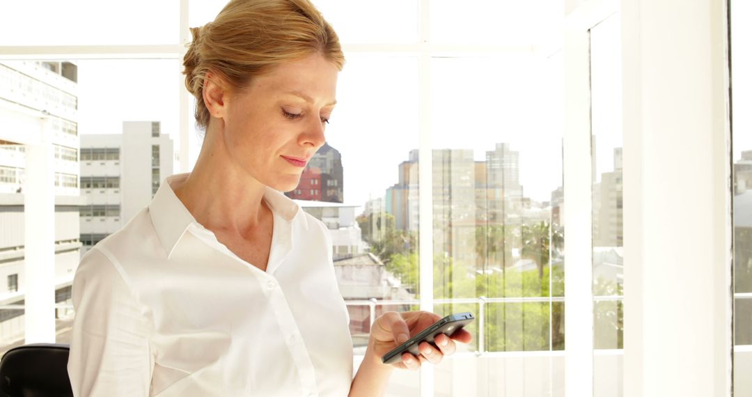 Professional Businesswoman Checking Phone in Modern Office - Free Images, Stock Photos and Pictures on Pikwizard.com