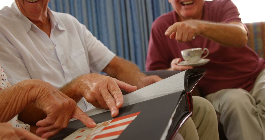 Joyful Seniors Reminiscing with Photo Album - Free Images, Stock Photos and Pictures on Pikwizard.com