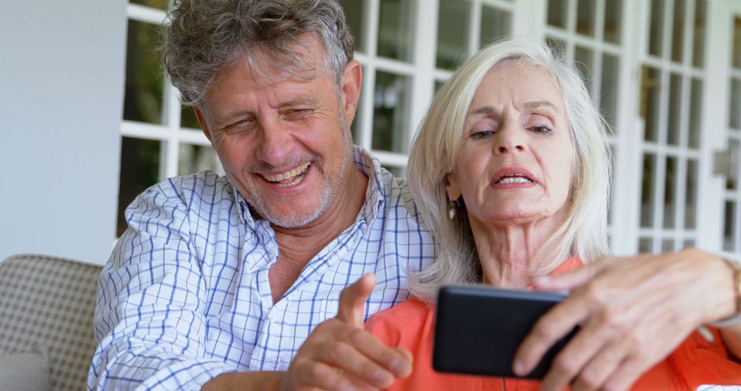 Happy Senior Couple Using Smartphone at Home