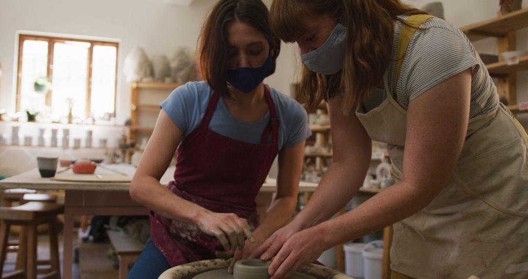 Women Engaged in Pottery Crafting Wearing Aprons and Face Masks - Free Images, Stock Photos and Pictures on Pikwizard.com