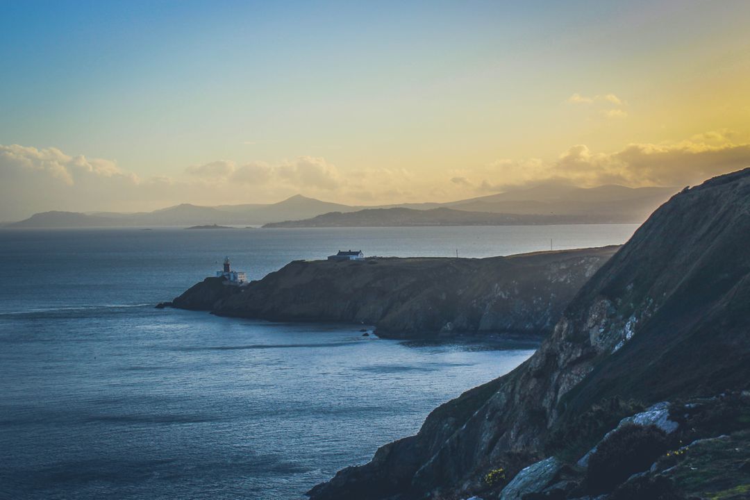 Scenic Coastal Lighthouse at Sunset with Mountains in Distance - Free Images, Stock Photos and Pictures on Pikwizard.com