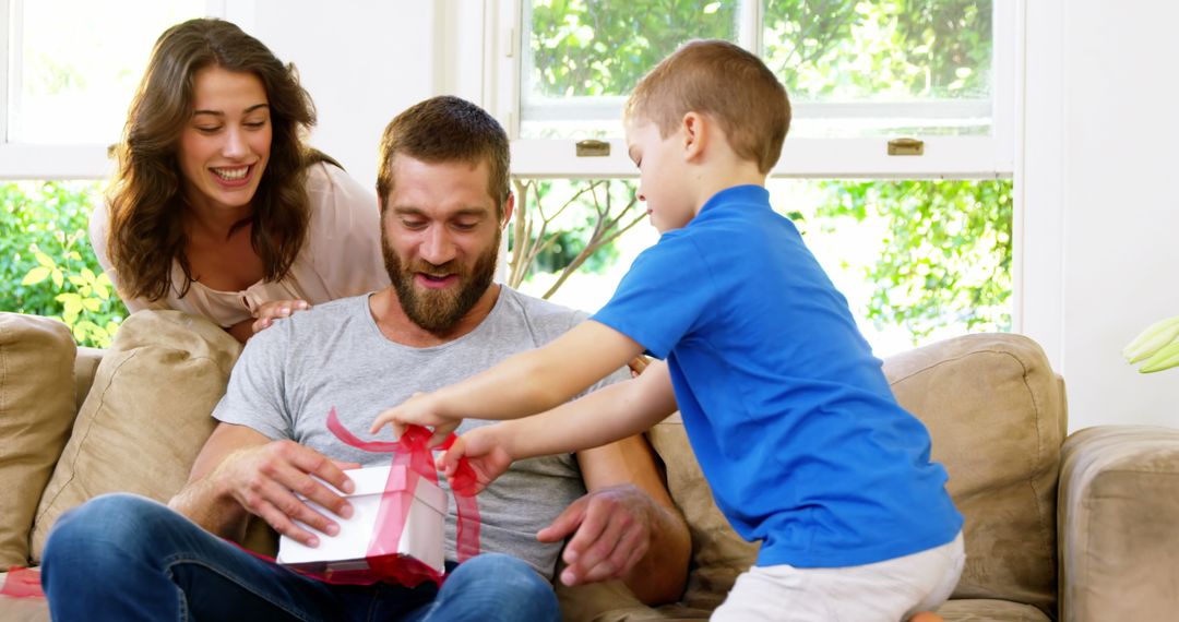 Family Celebrates Father's Day with Gift at Home - Free Images, Stock Photos and Pictures on Pikwizard.com